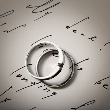 Stock photo: two wedding rings on a letter