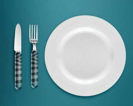 empty white plate with knife and fork on blue background.