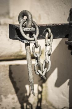 Metal hook with a chain attached to a wall