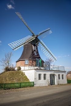 Windmill on a road in northern Germany in sunny weather and blue skies.