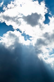 View of white clouds in blue sky with rays of light