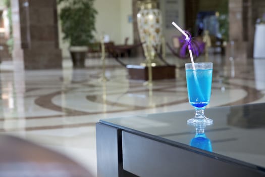 alcoholic cocktail of blue color is in the lobby of prestige hotel