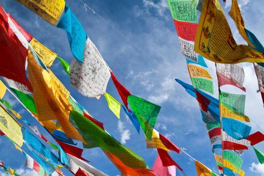 Buddhist tibetan prayer flags flying with blue sky