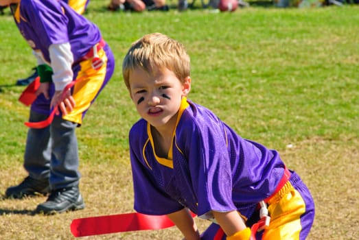 Youth flag football player with hands on knees.