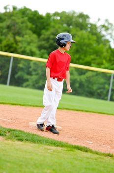 Youth baseball player standing on third base.