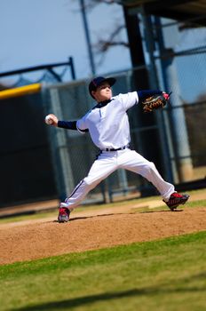 Little league baseball pitcher in white jersey