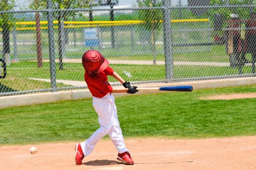 Youth baseball player swinging the bat.