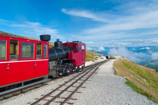 Austrian alpine cog railway train climbing up to the mountain