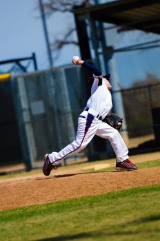 Little league baseball pitcher in the middle of a pitch.