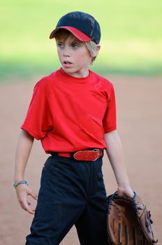 Little league baseball player looking sideways during a game.