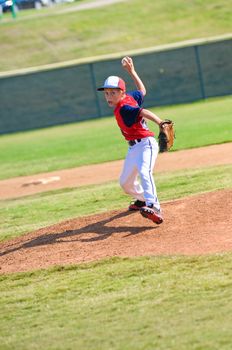 Little league baseball pitcher throwing the ball.