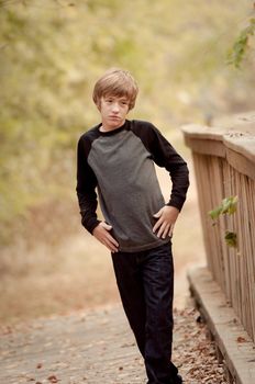 A depressed young teen walking on a bridge alone.