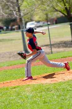 Teen baseball pitcher in the middle of throw