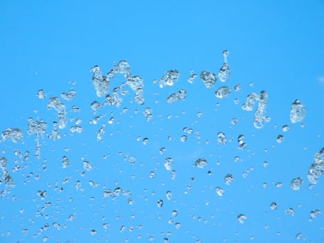 Splashes of a fountain against the blue sky