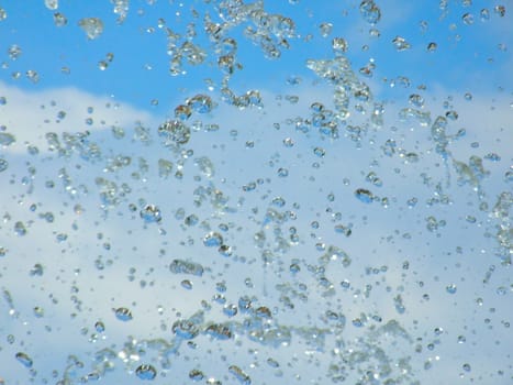 Splashes of a fountain against the blue sky