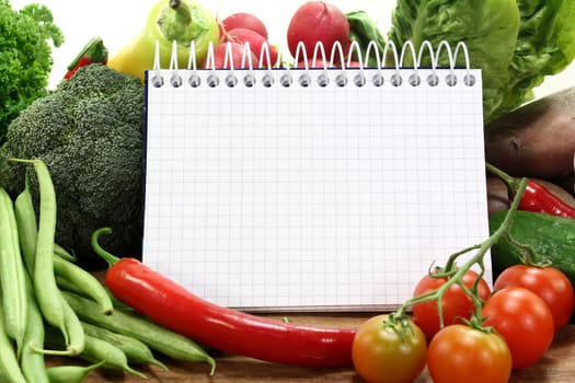 a checkered note pad and various vegetables