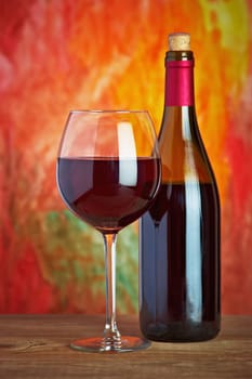 Wine, glass and the bottle on a colored background