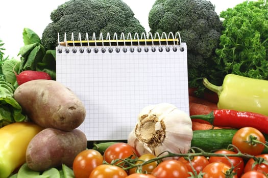 a checkered note pad and various vegetables