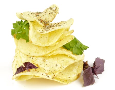 Potato Chips pyramid with basil and parsley isolated on white background