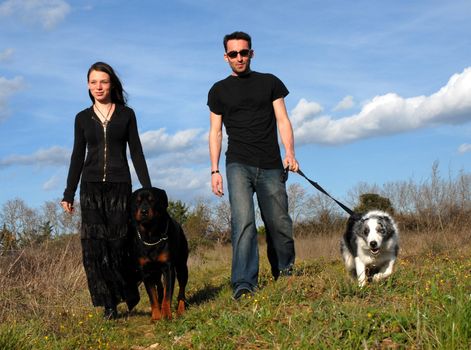 a young couple and their two dogs in a field