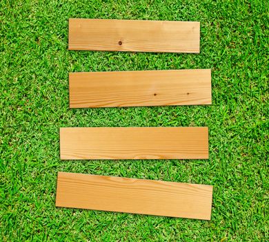 Wooden board on green grass