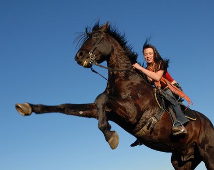 young woman and her rearing stallion outdoors