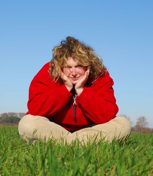 large smiling woman sitting in the nature