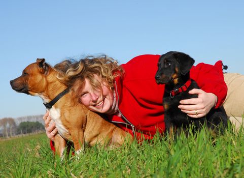 young woman and her two puppies in the grass