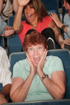 Seated mature woman screaming out in fear