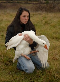 young teenager holding a white goose in her arm