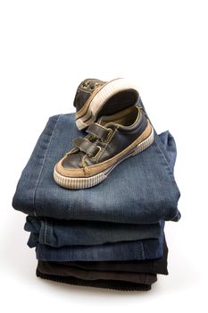 casual children's shoes putted on folded blue denim pants