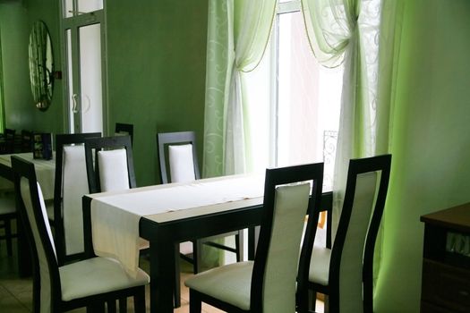 Empty cafe with a table and chairs illuminated with light from a window