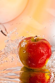 red ripe apple water splash over abstract background