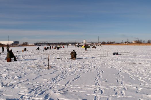 ice fishermens fishing on a frozen river