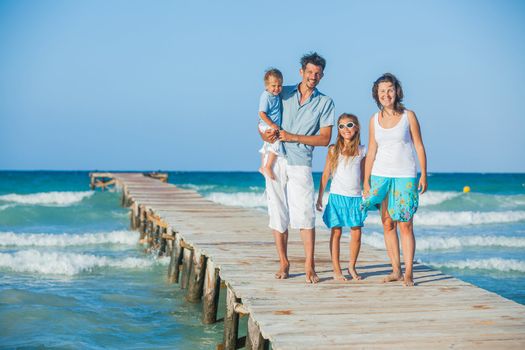 Family of four on wooden jetty by the ocean