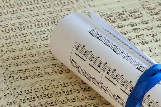 Rolled sheet music over a old sheet music