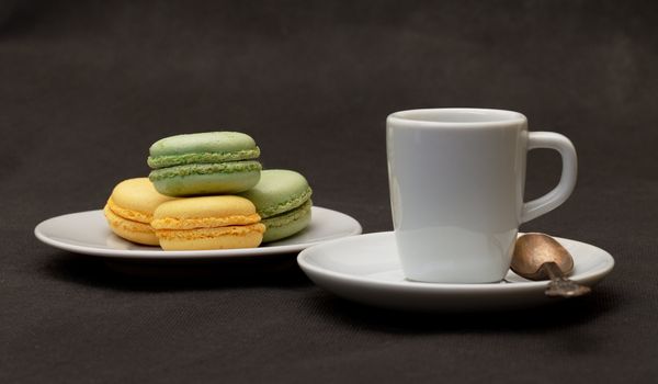 Cup coffee expresso and macaroon closeup on black