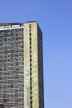 Facade of a rundown building in a poor neighborhood in the center of Sao Paulo, Brazil. It is occupied and covered with Gang symbols. 