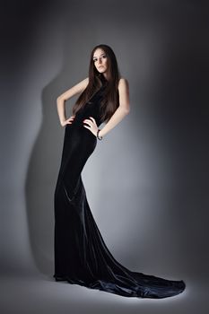 fashion woman in long dress on grey background