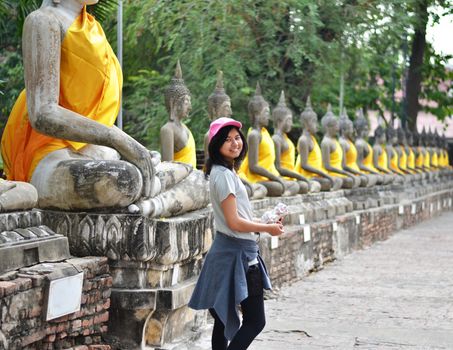 Beautiful asian woman and buddha at Wat Yai Chai Mongkol Temple. Ayutthaya - Thailand