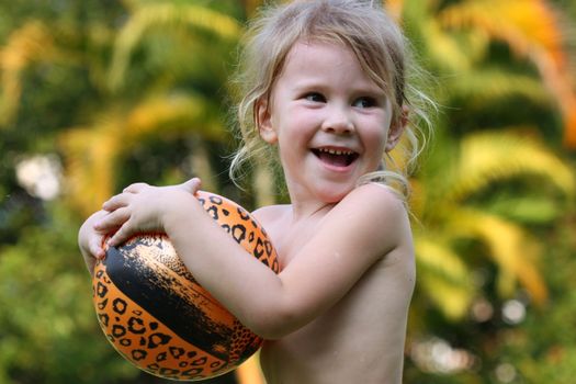 happy little girl holding a ball