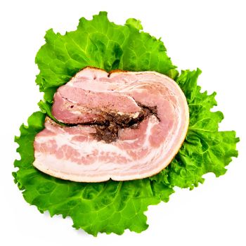 A large piece of meatloaf on the leaves of lettuce isolated on white background