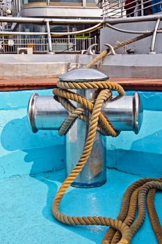 Metal bollard with rope on a ship deck