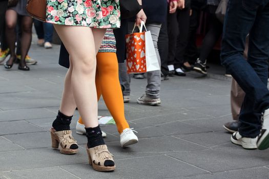 Women legs in crowd on a street