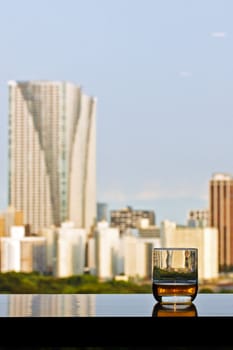 A glass of whisky with panoramic view of Tokyo on a background