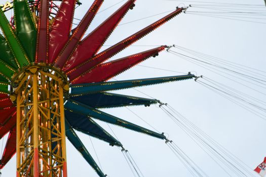 fun fair attraction chairoplane with cloudy sky