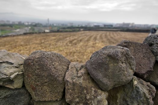 Fragment of dry stone wall and a field in a countryside