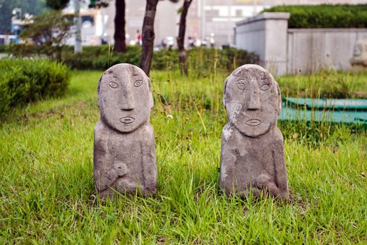 Two korean traditional stone figurines on a grass background