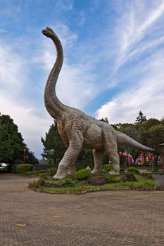 Brachiosaurus life-like figure in the park on sky background