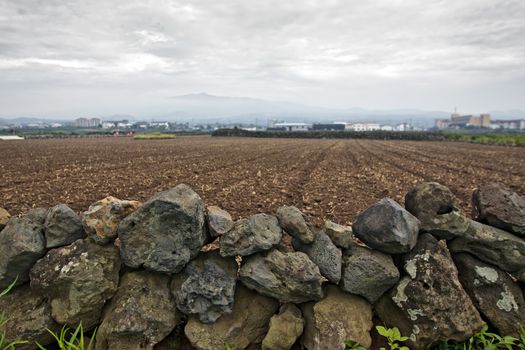 Fragment of dry stone wall and a field in a countryside